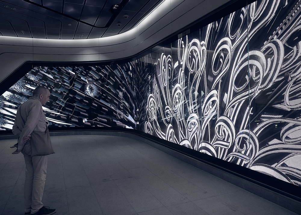 A man stands in front of Jon McCormack's video installation, The Unknowable