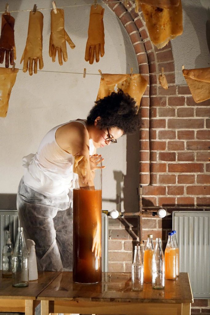 Alanna Lynch dips her hand into a kombucha jar