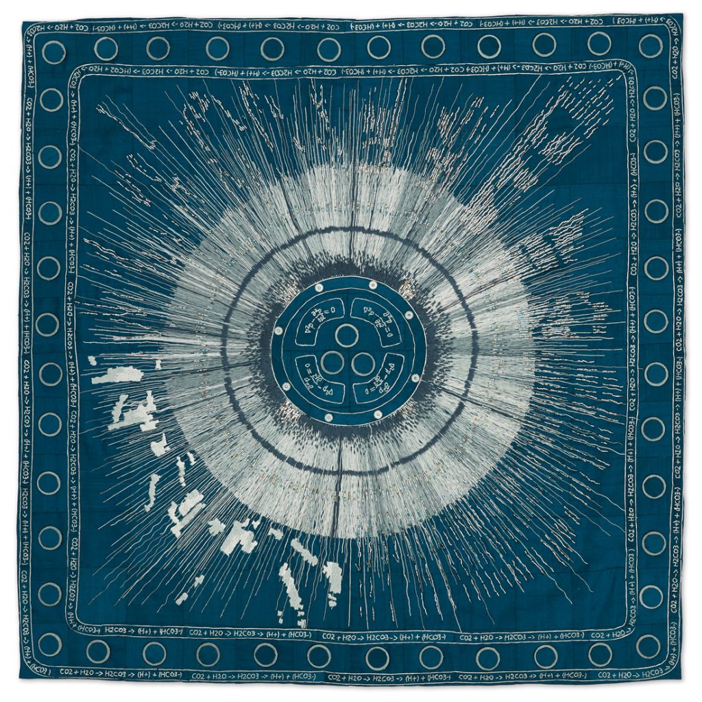 Large embroidered piece, looks like the sun on a blue background