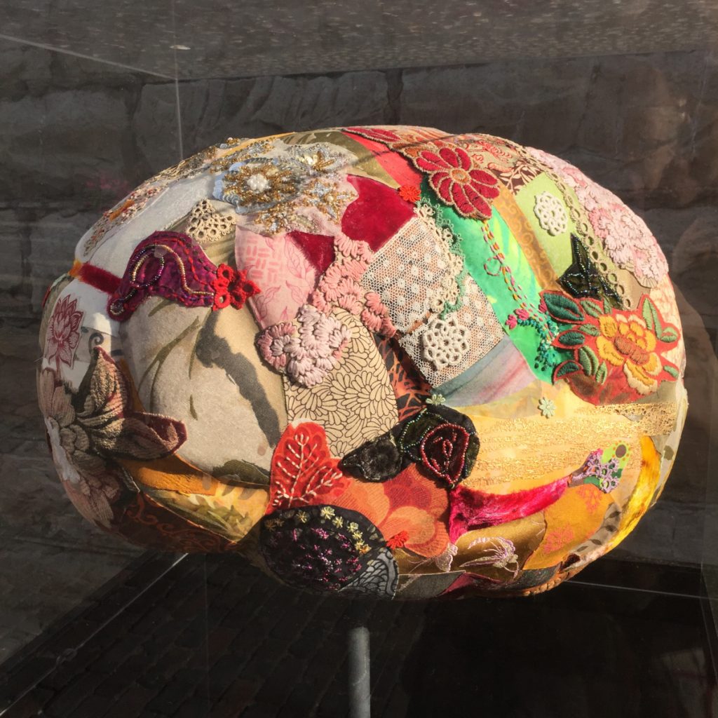 Three dimensional structure of a brain made with different fabrics and other materials. 