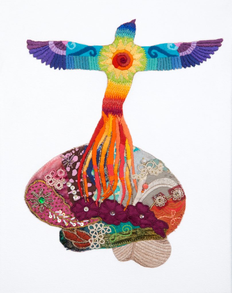 Colorful embroidered phoenix rising from a colorful brain made of different fabrics and materials. 