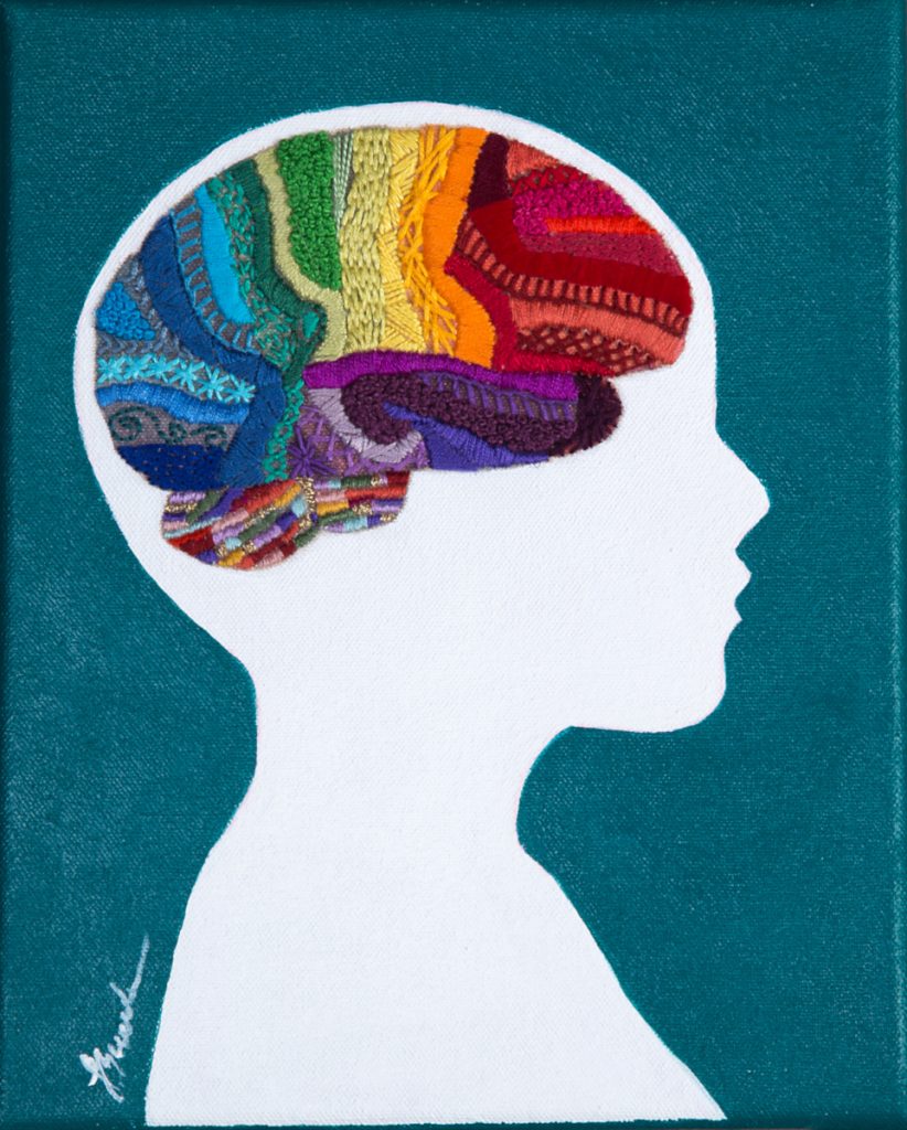 Colorful embroidered brain within a white side profile of a head. 