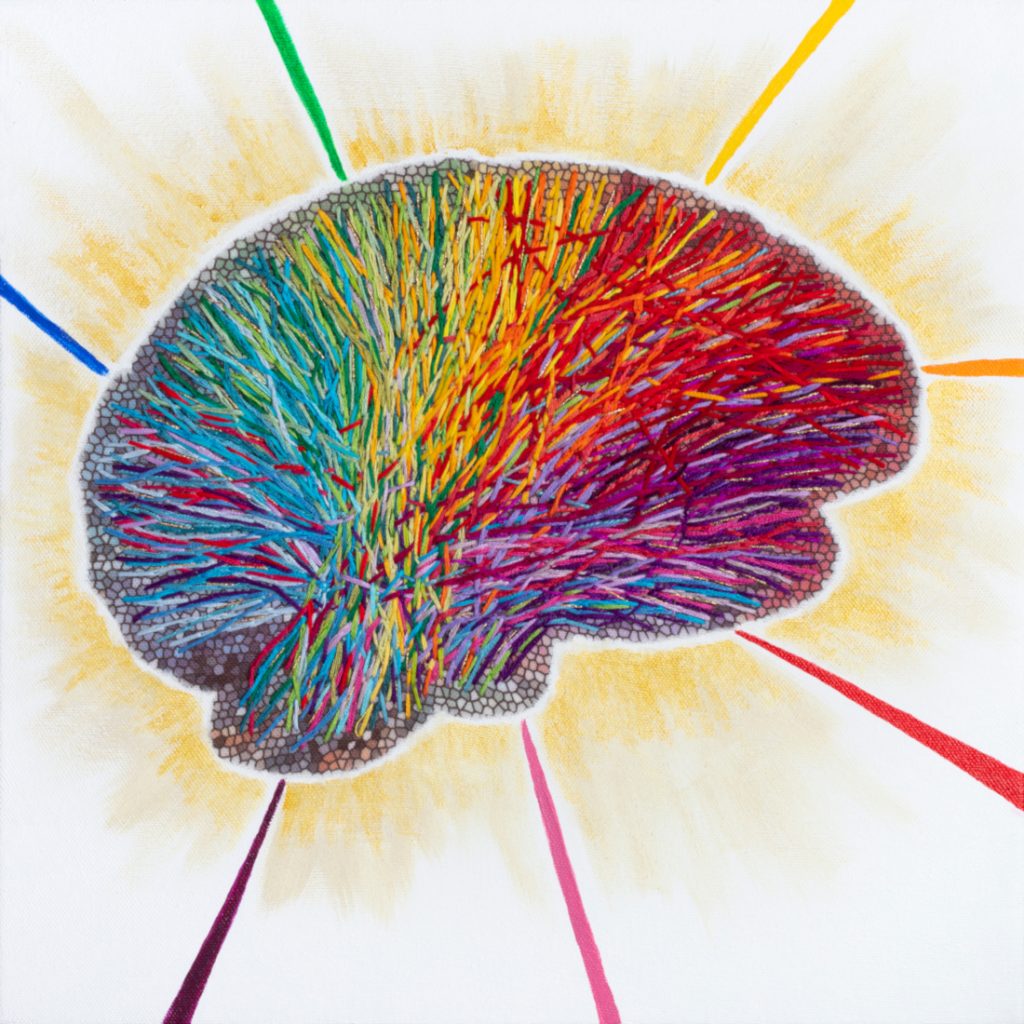 Colorful embroidered brain with rays of light and rainbow coming out of it. 