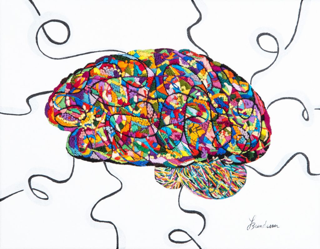 Brain embroidered with small patches of different colors. A few black spirals are coming out of the brain. 