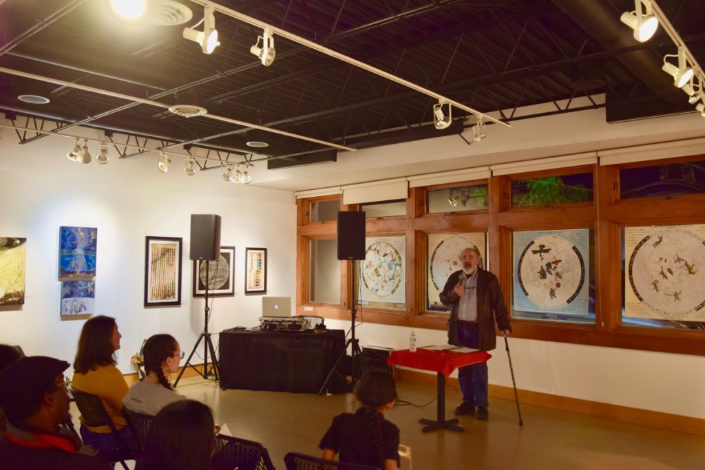 Native Skywatchers team member discussing the exhibition in front of an audience. 