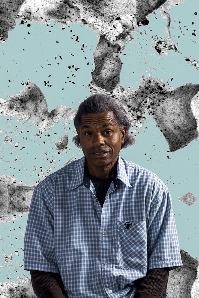Portrait of a man wearing a checkered shirt in front of a teal background with black and white cells.