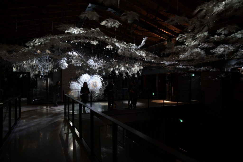 View of the icy sculpture with its feathered hanging pieces and illuminated starbursts.  