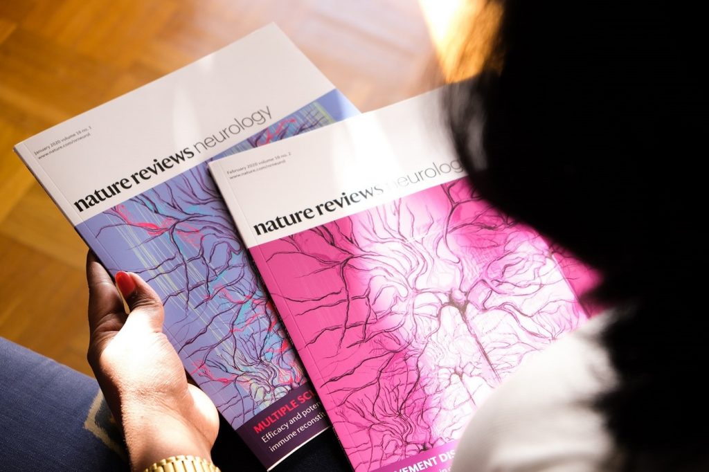 The Guardians – Featured on Nature Reviews Neurology (2020) by Dr Radhika. 
Dr Radhika holding the nature journal with her cover image of neurons. 