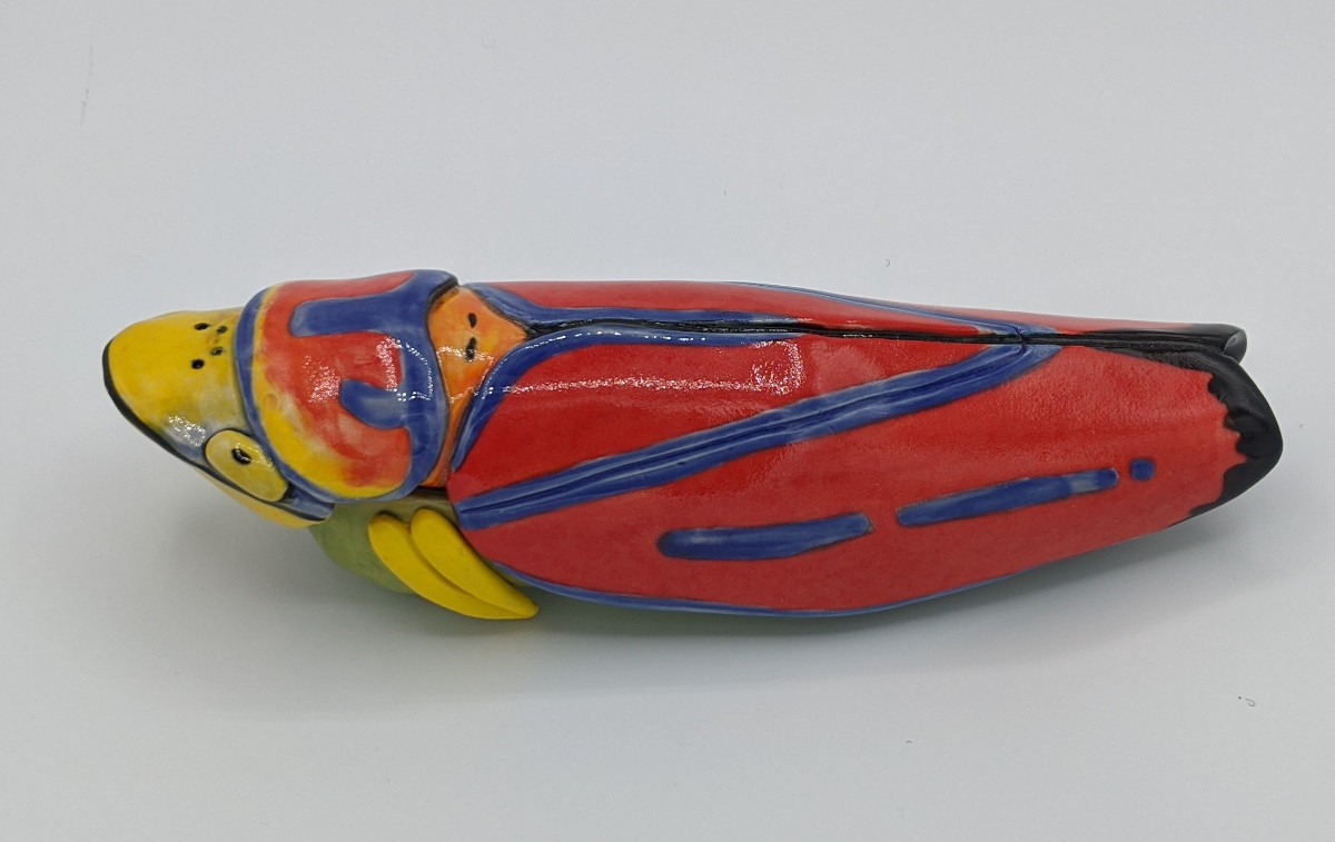 Pottery of a long, colourful leafhopper insect