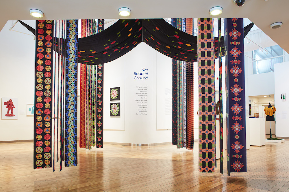 "Birthing Tent" by Daphne Boyer. A large velvet canopy, printed with the oxytocin molecule so that its chemical structure looks almost like a constellation, hangs from the ceiling in the shape of a bosom. Around it hang wide silk ribbons of various patterns. All printed images are composed from digitally photographed berries.